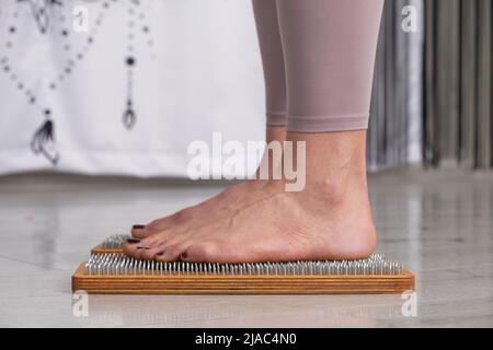 Nagel stehen Praxis Frau Beine auf Sadhu Bord Yoga Meditation Fußmassage Stockfoto