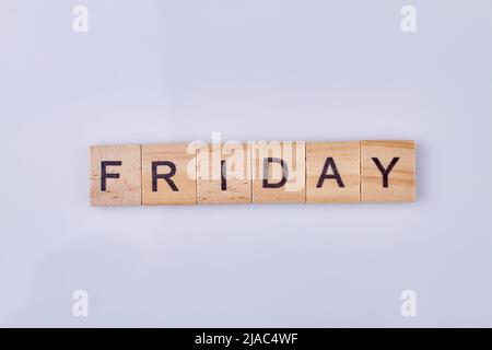Freitagswort auf handgefertigten Holzwürfeln vor weißem Hintergrund geschrieben. Wochentagskonzept. Stockfoto
