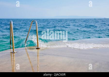 Treppen Zum Meer. Metalltreppe mit Geländer zum Meer. Metalltreppe Führt Zum Meer. Treppe Zum Meer. Sommerhitze Stockfoto