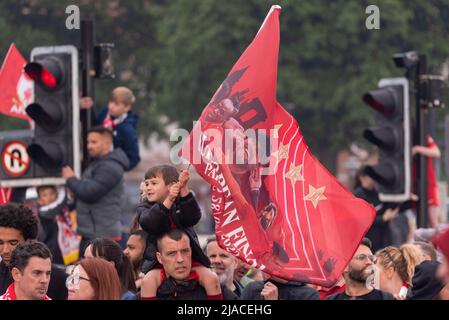 Baltic Triangle, Liverpool, Großbritannien. 29.. Mai 2022. Die Open-Top-Busparade zur Feier der Trophäengewinne des FC Liverpool fand in der Stadt statt, bei der der Manager und die Spieler des Teams den Applaus der Fans auf den Straßen entgegennahmen. Junger Fan mit großer Flagge Stockfoto