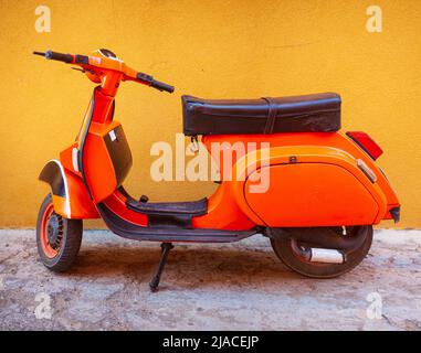 Orange Vespa, berühmtes italienisches Motorrad, das in der Straße von Linosa geparkt ist Stockfoto
