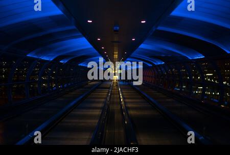 Skylink/Overhead-Travellator am Manchester International Airport, Greater Manchester, der einen neonähnlichen Effekt erzeugt. Stockfoto