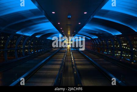 Skylink/Overhead-Travellator am Manchester International Airport, Greater Manchester, der einen neonähnlichen Effekt erzeugt. Stockfoto