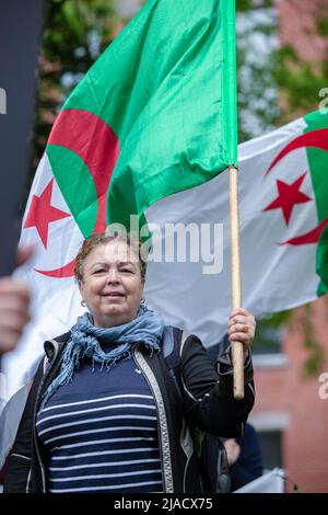 Leïla Cheurfi hält die algerische Flagge, während sie während des Protestes die Namen ihrer entführten Angehörigen singt. Vier Jahre in der algerischen Diaspora kämpft die Hirak-Bewegung in Montreal weiterhin für Demokratie. Organisiert von Tous unis pour notre Algerie versammelten sich vor dem algerischen Konsulat hundert Demonstranten, um die Entfernung der aktuellen politischen Führer unter der Leitung von Präsident Abdelmadjid Tebboune zu fordern. Unter Berufung auf die chronische Korruption und den Mangel an vorhersehbaren Resolutionen nannten die Demonstranten die Regierung eine Mafia-Regierung. Stockfoto