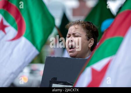 Leïla Cheurfi hält die algerische Flagge, während sie während des Protestes die Namen ihrer entführten Angehörigen singt. Vier Jahre in der algerischen Diaspora kämpft die Hirak-Bewegung in Montreal weiterhin für Demokratie. Organisiert von Tous unis pour notre Algerie versammelten sich vor dem algerischen Konsulat hundert Demonstranten, um die Entfernung der aktuellen politischen Führer unter der Leitung von Präsident Abdelmadjid Tebboune zu fordern. Unter Berufung auf die chronische Korruption und den Mangel an vorhersehbaren Resolutionen nannten die Demonstranten die Regierung eine Mafia-Regierung. Stockfoto