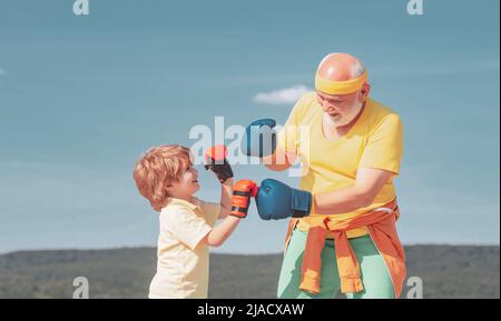 Gesunder Kämpfer Großvater und Enkel mit Boxhandschuhen. Großvater und Enkel machen morgens ein Boxtraining. Boxen. Stockfoto