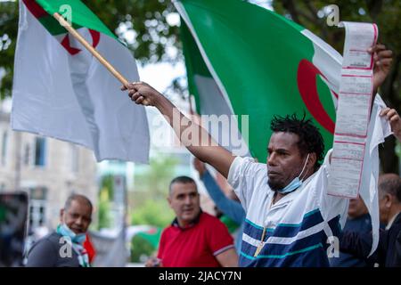 Alexandre Roland, ein haitianischer Zuschauer, erhielt von der SPVM (Polizei von Montreal) ein Ticket, nachdem er zur Unterstützung des Protestes das Hupen seines Autos anschallte, woraufhin er sich dem Protest anschloss. Vier Jahre in der algerischen Diaspora kämpft die Hirak-Bewegung in Montreal weiterhin für Demokratie. Organisiert von Tous unis pour notre Algerie versammelten sich vor dem algerischen Konsulat hundert Demonstranten, um die Entfernung der aktuellen politischen Führer unter der Leitung von Präsident Abdelmadjid Tebboune zu fordern. Unter Berufung auf die chronische Korruption und den Mangel an vorhersehbaren Resolutionen nannten die Demonstranten die Regierung als ma Stockfoto