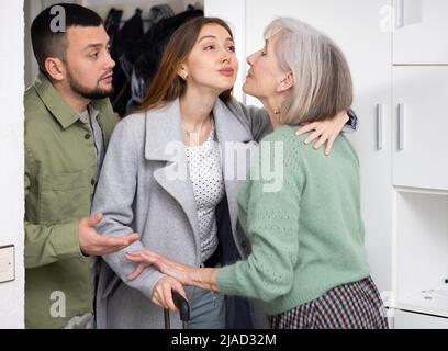 Ältere Frau, die das Paar zu Hause begrüßt Stockfoto