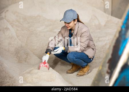 Eine Bäuerin hockt auf einem Haufen Maismehl Stockfoto