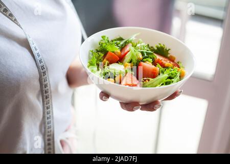 Schüssel grün gesund lecker Öko-Salat in der Hand Frau auf leichte Küche Stockfoto