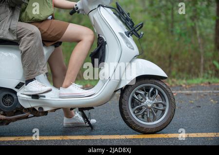 Nahaufnahme eines Paares, das auf einem Roller sitzt Stockfoto