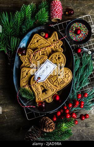 Ansicht von oben mit verschiedenen Lebkuchen, Weihnachtskekse auf einem Teller mit Weihnachtsdekorationen Stockfoto
