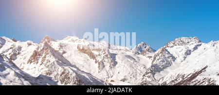 Panorama der Winter verschneiten Berge in der Kaukasus-Region in Russland mit heller Sonne auf dem Hintergrund Stockfoto