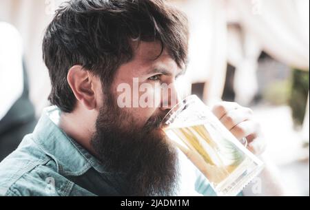 Das Festkonzept des oktoberfests. Schöner bärtiger Mann, der Bier trinkt. Stockfoto