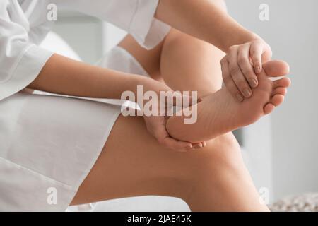 Junge Frau macht Fußmassage, Nahaufnahme Stockfoto