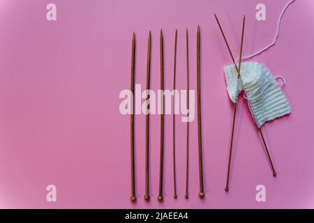 stricknadeln auf rosa Hintergrund Stockfoto