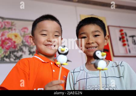 BINZHOU, CHINA - 30. MAI 2022 - Kinder zeigen ihr Cartoon-Gesicht, Mannarbeiten, Stadt Binzhou, Provinz Shandong, China, 30. Mai, 2022. Stockfoto