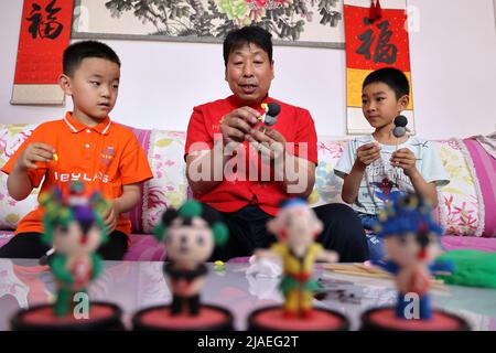 BINZHOU, CHINA - 30. MAI 2022 - der Künstler Liu Yangui lehrt Kinder, Comicfiguren aus Teig zu machen, Stadt Binzhou, Provinz Shandong, China, 30. Mai 20 Stockfoto