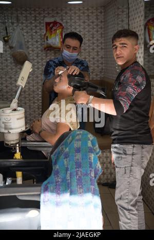 Amman, Jordanien - 06 2021. Oktober: Markt in der Innenstadt in der Hauptstadt Amman, Mann, der im Friseur amman eine Gesichtsbehandlung macht Stockfoto