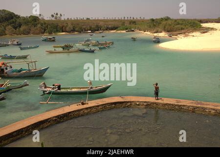 Ein Fischer, der auf einem Betonweg am Fischerstrand von Pero in Pero Batang Villlage, Kodi, Südwesten Sumbas, Ost-Nusa Tenggara, Indonesien steht. Stockfoto