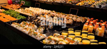 Verschiedene Sushi-Nigiri- und Maki-Sets. Eine Auswahl an japanischem Sushi mit Thunfisch, Krabben, Lachs und Brötchen. Japanisches Essen. Stockfoto