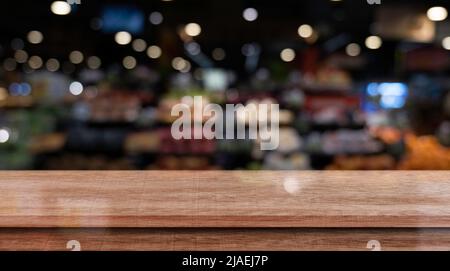Leere Holztischplatte vor abstraktem Hintergrund des Restaurants. Stockfoto