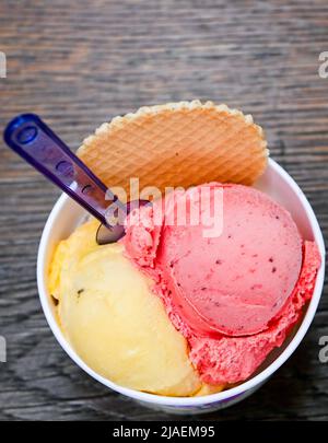 Berlin, Deutschland. 24.. Mai 2022. Eisbecher mit Schaufeln verschiedener Eisarten stehen auf einem Tisch in der Eiskultur-Eisdiele in Schöneweide. Eis und Sorbet gehören für viele Deutsche zum Sommer. Jedes Jahr werden neue Geschmacksrichtungen zum Trend erklärt. Viele bevorzugen jedoch die klassischen Aromen von Vanille, Schokolade und Erdbeere. (To dpa: „Sommertrends 22: Fischhüte in, Booties out?“) Quelle: Jens Kalaene/dpa/Alamy Live News Stockfoto