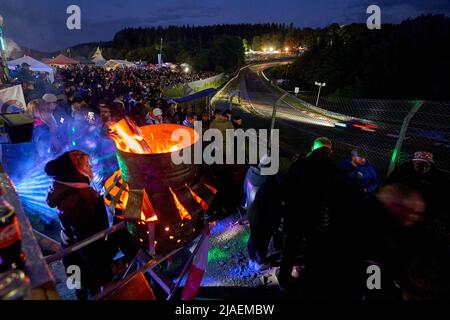 28. Mai 2022, Rheinland-Pfalz, Nürburg: Motorsport: 24-Stunden-Rennen auf dem Nürburgring: Motorsport-Fans beobachten das Rennen in der Nacht und feiern am Streckenrand. Erstmals findet das Rennen wieder weitgehend ohne Corona-Anforderungen statt. Foto: Thomas Frey/dpa Stockfoto