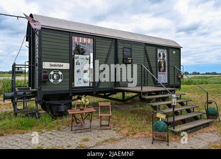 28. Mai 2022, Brandenburg, Groß Neuendorf: Am Hafen an der deutsch-polnischen Grenze oder steht ein ehemaliger Eisenbahnwaggon, in dem sich ein kleines Theater befindet. Am 27.05.2022 begannen die dreitägigen 24. Art Loose Days im Oderbruch in Ostbrandenburg. Präsentiert werden Gemälde, Keramik, Schmuck und Fotografie von rund 40 Künstlern, die ihre Ateliers und Höfe für Besucher öffnen. Viele Künstler aus der Region leben auf so genannten losen Bauernhöfen - weit verstreut im Oderbruch. Der Oderbruch entstand nach der Entwässerung vor fast 270 Jahren, wurde vom preußischen König Friedrich II. Mit Kolonisten und besiedelt Stockfoto