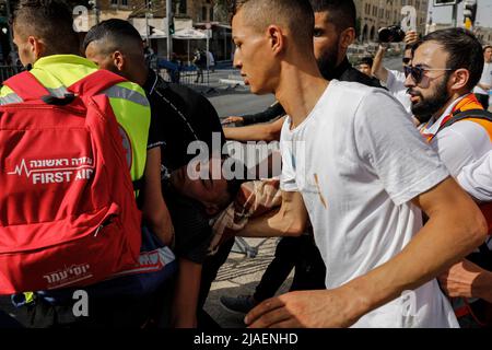 Jerusalem, Israel. 29.. Mai 2022. Sanitäter tragen einen Mann weg, der bei Zusammenstößen mit Israelis, die am Flag March teilnehmen, einer von nationalistischen Israelis organisierten Kundgebung anlässlich des Jerusalemtages, verletzt wurde. Quelle: Ilia Yefimovich/dpa/Alamy Live News Stockfoto