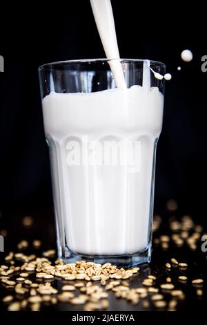 Bremen, Deutschland. 23.. Mai 2022. ABBILDUNG - Hafermilch wird in ein Glas gegossen. (Posierte Szene) in der Vergangenheit war klar, dass „Milch“ Kuhmilch bedeutete. Das ist heute in Deutschland anders. Pflanzliche Milchalternativen aus Hafer zum Beispiel boomen. Der Verbrauch von Kuhmilch sinkt. (To dpa: 'Es ist die Milch, die es tut - für manche nicht mehr') Quelle: Sina Schuldt/dpa/Alamy Live News Stockfoto