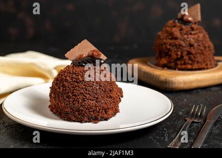 Schokoladenkuchen im besonderen Design. Schokoladenkuchen auf dunklem Hintergrund. Nahaufnahme Stockfoto