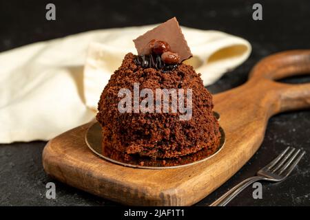 Schokoladenkuchen im besonderen Design. Schokoladenkuchen auf dunklem Hintergrund. Nahaufnahme Stockfoto