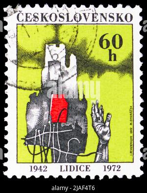 MOSKAU, RUSSLAND - 14. MAI 2022: Briefmarke gedruckt in der Tschechoslowakei gewidmet 30. Jahrestag der Zerstörung von Lidice, Hand und ruinierte Gebäude Stockfoto