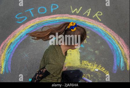 Kinder zeichnen das ukrainische Flaggenhaus auf den Bürgersteig. Selektiver Fokus. Stockfoto