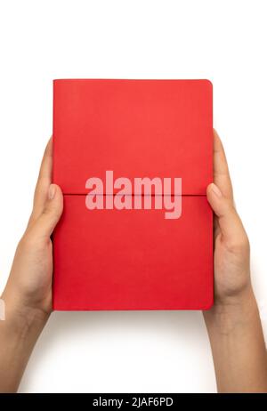 Weibliche Hände mit rotem Buch mit leerem Einband auf weißem Hintergrund, Draufsicht Stockfoto