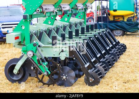 Ein Fragment des Radstandes einer mehrreihigen Sämaschine mit lockeren Messern, die als Anhänger für einen Traktor verwendet wird.Platz kopieren. Nahaufnahme. Stockfoto