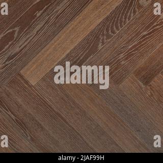 Dunkle Holzbretter mit hellbrauner Textur, symmetrisch zueinander in Form eines Fischgrätes angeordnet. Stockfoto