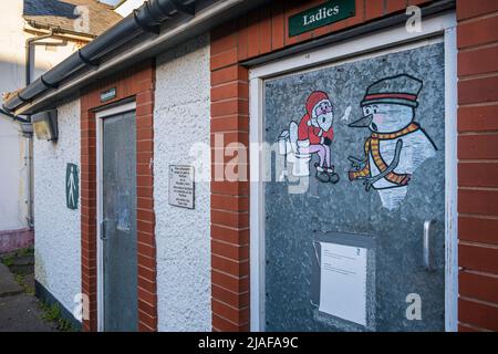 Graffiti-Kunst mit einem Weihnachtsmann und einem Schneemann auf einer öffentlichen Toilette in Caerleon, Monmouthshire, Südwales Stockfoto