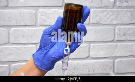 Medizinischer Tropfer und die Hand des Arztes in einem Handschuh Stockfoto