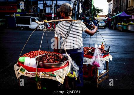 Ein Obstverkäufer geht auf die Straßen. Tägliches Leben auf den belebten Straßen von Yangon. Yangon, die ehemalige Hauptstadt von Myanmar, ist immer noch die größte Stadt und das Industrie- und Handelszentrum des Landes. Tägliches Leben auf den belebten Straßen und den wichtigsten Sehenswürdigkeiten von Yangon, der ehemaligen Hauptstadt von Myanmar. Die Stadt ist immer noch das größte und das Industrie- und Handelszentrum des Landes. Stockfoto