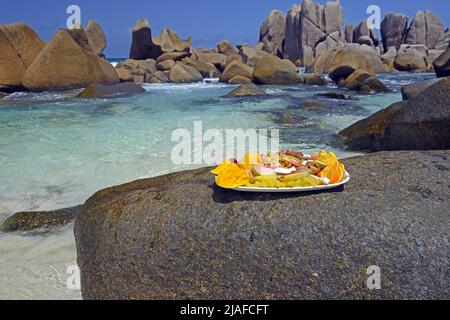 Teller mit exotischen Früchten am Traumstrand Anse Marron, auch La Source Marron, Seychellen, La Digue genannt Stockfoto