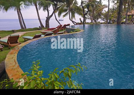 Swimmingpool eines Luxushotels am Lovina Beach mit Blick auf den Indischen Ozean, Indonesien, Bali Stockfoto