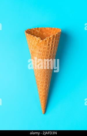 Leere Eiszapfen-Waffel in Nahaufnahme auf hellblauem Hintergrund. Stockfoto