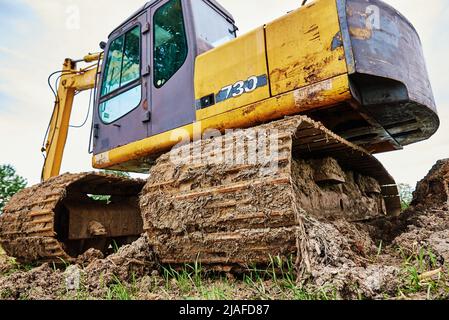 Gelber Bagger auf der Baustelle, Schwere Baumaschine Aushub Boden, Raupenbagger arbeiten auf Schmutz Boden Stockfoto