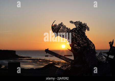 Lebensgroße skulpturale Figur im D-Day 75 Garden in Arromanches-les-Bains, Frankreich bei Sonnenuntergang. Die Installation wurde zuerst von John Everiss für erstellt Stockfoto