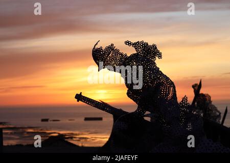 Lebensgroße skulpturale Figur im D-Day 75 Garden in Arromanches-les-Bains, Frankreich bei Sonnenuntergang. Die Installation wurde zuerst von John Everiss für erstellt Stockfoto