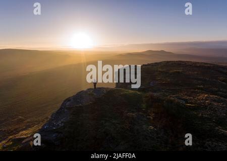 Walker genießt den Blick von Goldsborough Hill bei Sonnenuntergang, Baldersdale, Teesdale, County Durham, Großbritannien Stockfoto