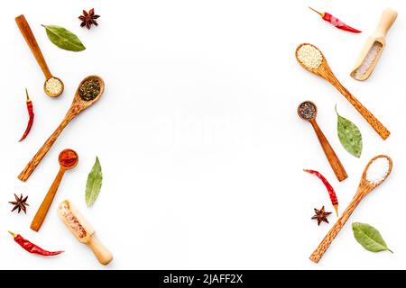 Vielfalt an bunten Gewürzen und Kräutern in Holzlöffeln auf Küchentisch, Draufsicht Stockfoto