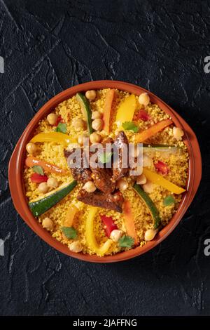 Fleisch und Gemüse Couscous, festliche arabische Speisen mit Kichererbsen, auf dunklem Hintergrund, von oben geschossen Stockfoto